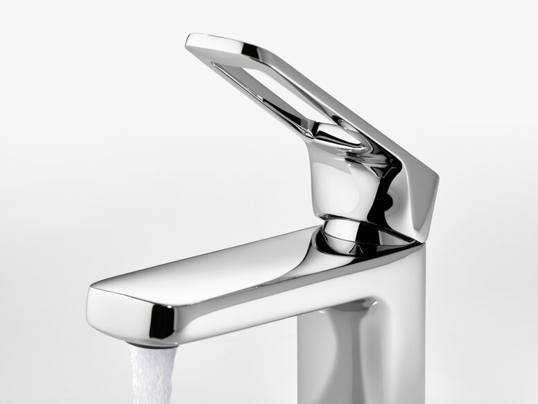 Stainless steel washbasin tap with a straight spout and side lever, shown with running water