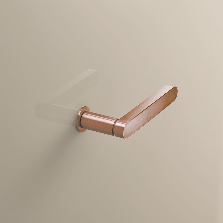 Copper-coloured PVD door handle with a brushed surface, a round rose and a rectangular end cap on a beige wall