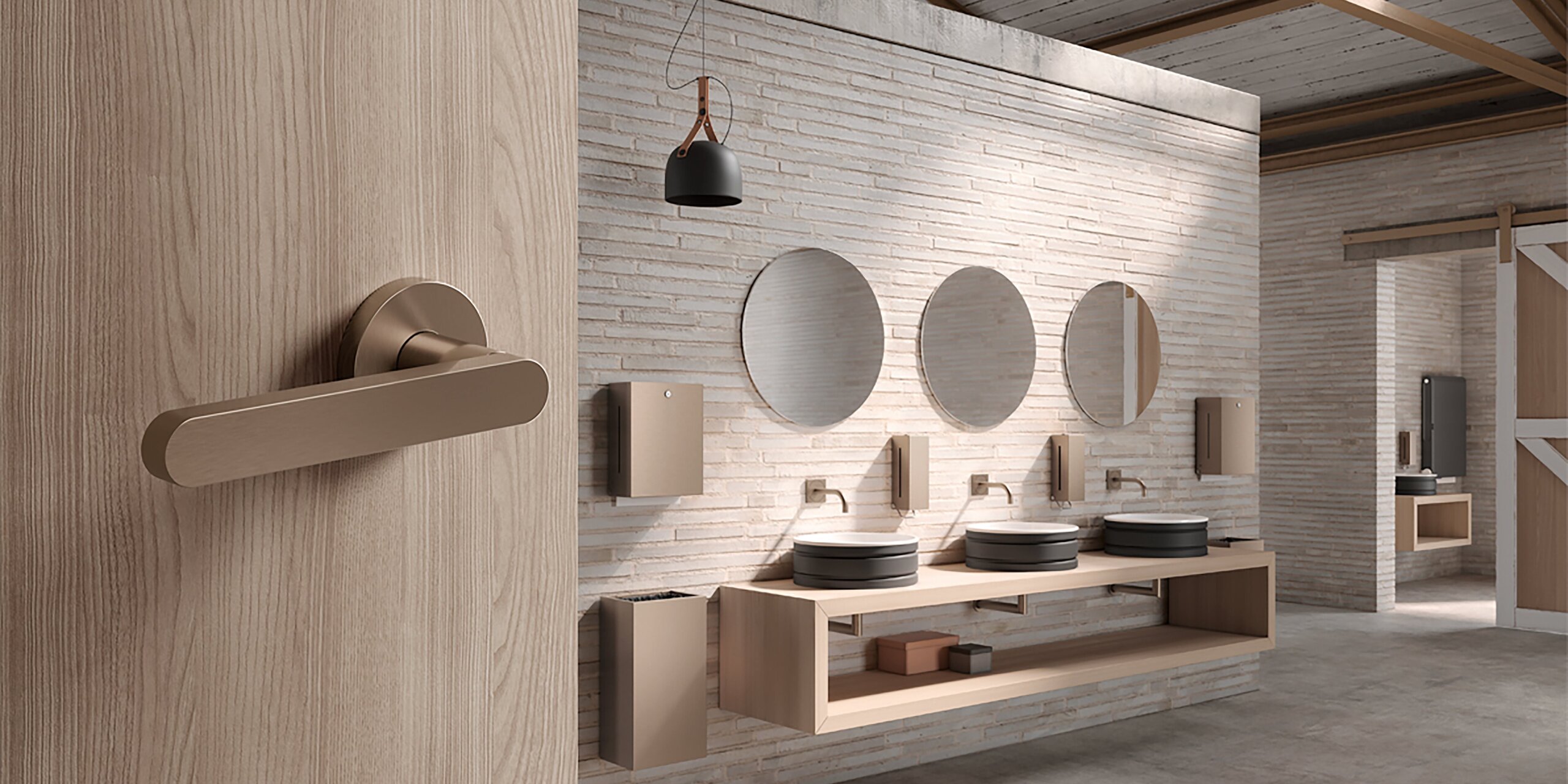 A PVD door handle with a metallic finish on a wooden door in a bathroom, featuring three round mirrors and a washbasin against a light-coloured brick wall