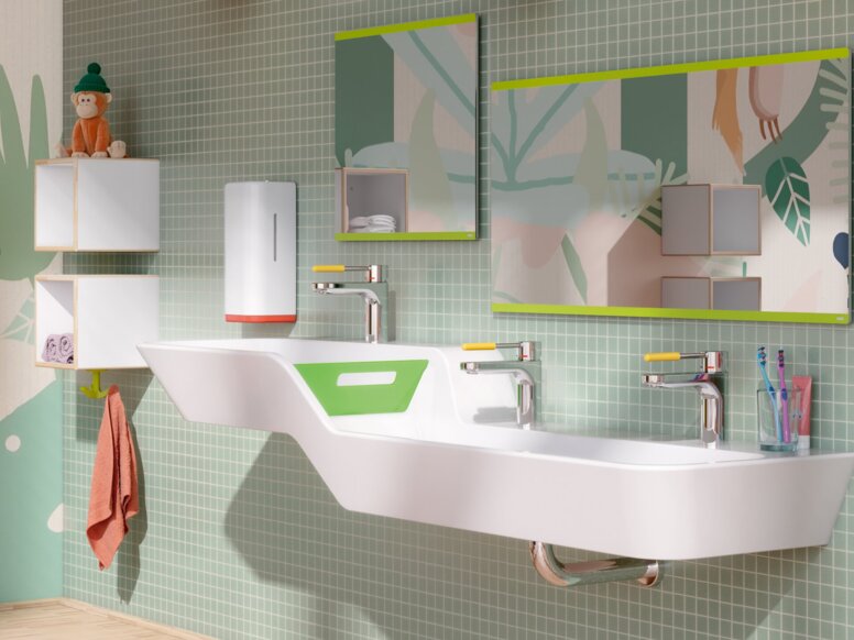 Double washbasin with taps and two rectangular mirrors on a section of wall tiled in green in the children’s bathroom