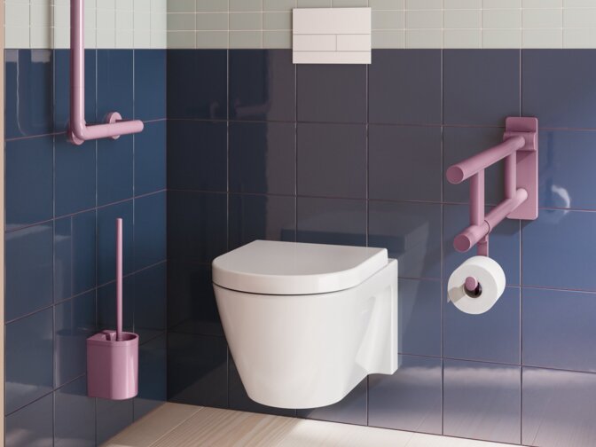 Wall-hung toilet with a purple hinged support rail, toilet roll holder, support rail and toilet brush unit against blue-grey tiles