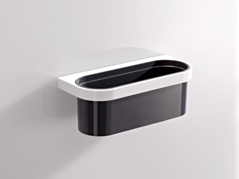 Wall-mounted synthetic material storage box with a white frame and black insert on a light grey wall