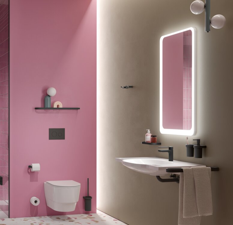 A hinged seat next to the shower handrail in a shower cubicle with a stool and pink tiles, next to which is a WC and a washbasin with a mirror