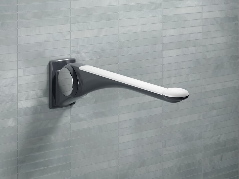 HEWI Range 802 LifeSystem premium hinged support rail handle A hinged support rail made of dark grey synthetic material with an ergonomic white handle, fitted to a light grey tiled wall