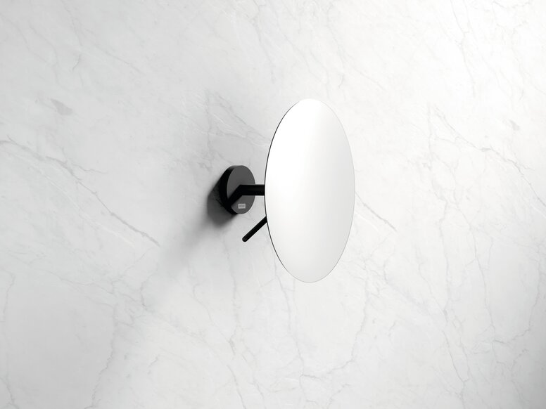 Wall mirror with a round mirror pane and a black holder for wall mounting against a white marble background
