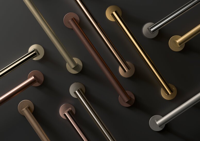 Several diagonally arranged grab rails in different shades of gold, bronze and silver-grey against a dark grey background