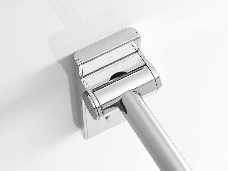Close-up of the chrome-plated hinge section of a Mono hinged support rail with a rectangular wall mounting plate and a rail extending diagonally downwards