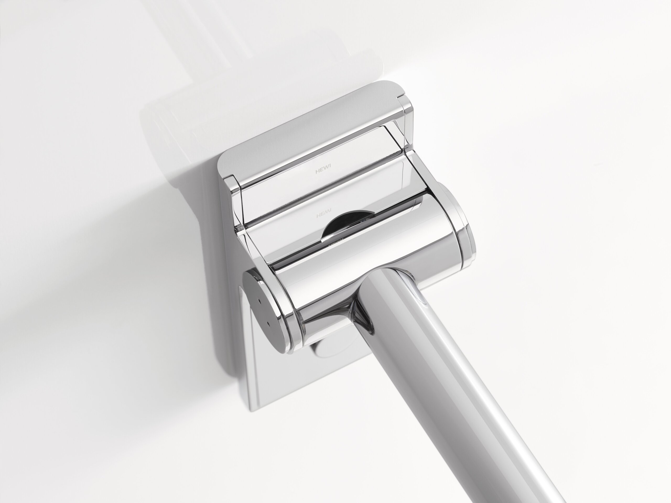 Close-up of the chrome-plated hinge section of a Mono hinged support rail with a rectangular wall mounting plate and a rail extending diagonally downwards
