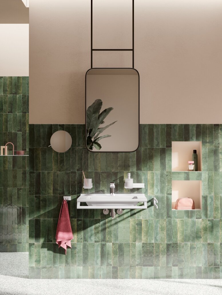 Accessible washbasin with tap, wall-hung WC and accessible shower area with a hinged seat against a green tiled wall