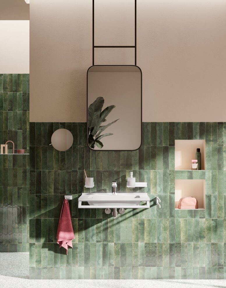 HEWI System 900Q Interieur Barrierefreies Waschbecken mit Wasserhahn sowie wandhängendes WC und barrierefreier Duschbereich mit Klappsitz an grüner Fliesenwand