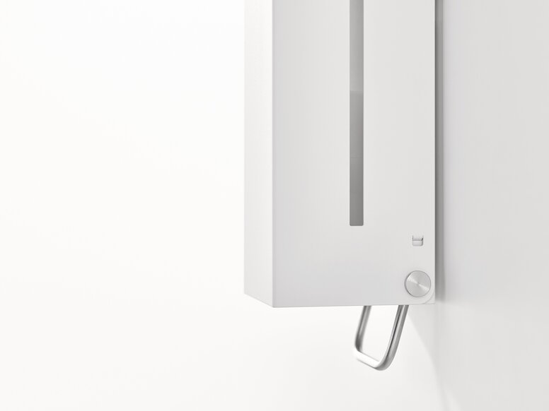 White wall-mounted soap dispenser with a viewing window and an operating lever on the underside against a white background