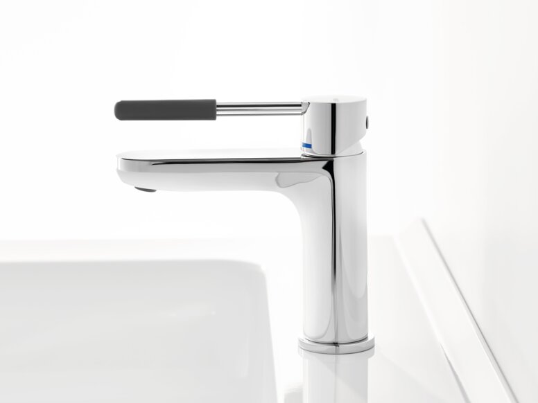 Chrome-plated tap with a long lever handle and dark grey grip sleeve on a white washbasin against a white background