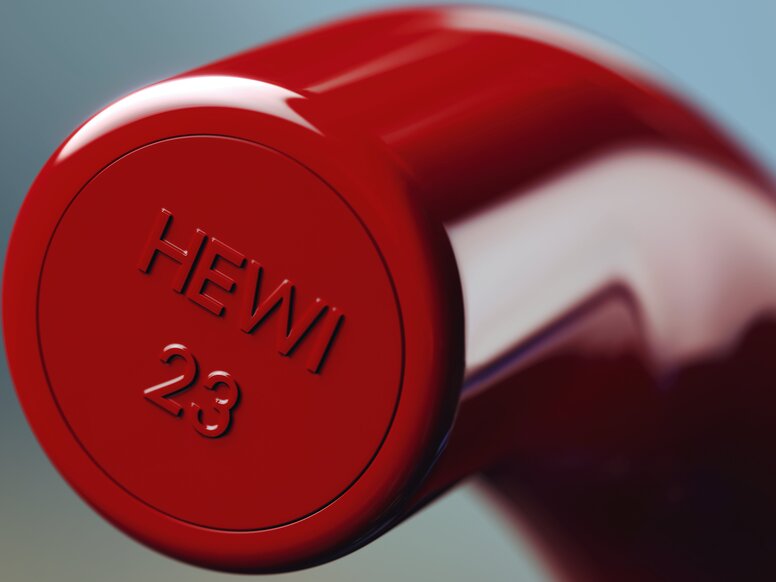 HEWI System 111 Door Handle – Detail Close-up of the glossy red, rounded end of a cylindrical door handle with embossed HEWI lettering and the number 23